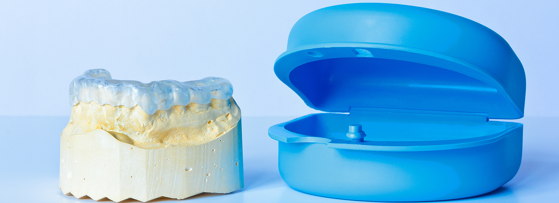 The image displays a blue toothbrush head next to a yellow dental implant.