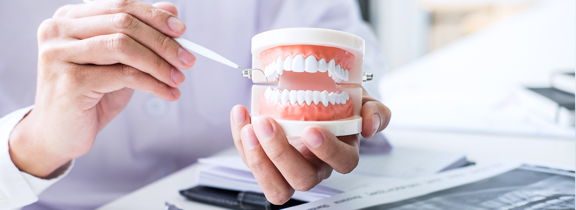 The image features a person holding a toothbrush with toothpaste over a cup of water, with a background showing a dental office setting with a dentist examining a patient s teeth.