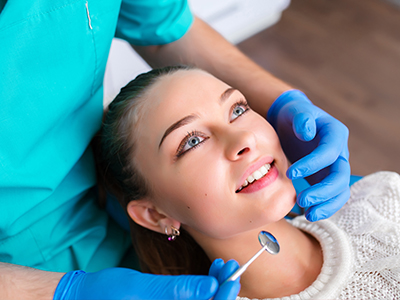 A smiling woman receiving dental care from a dental professional.